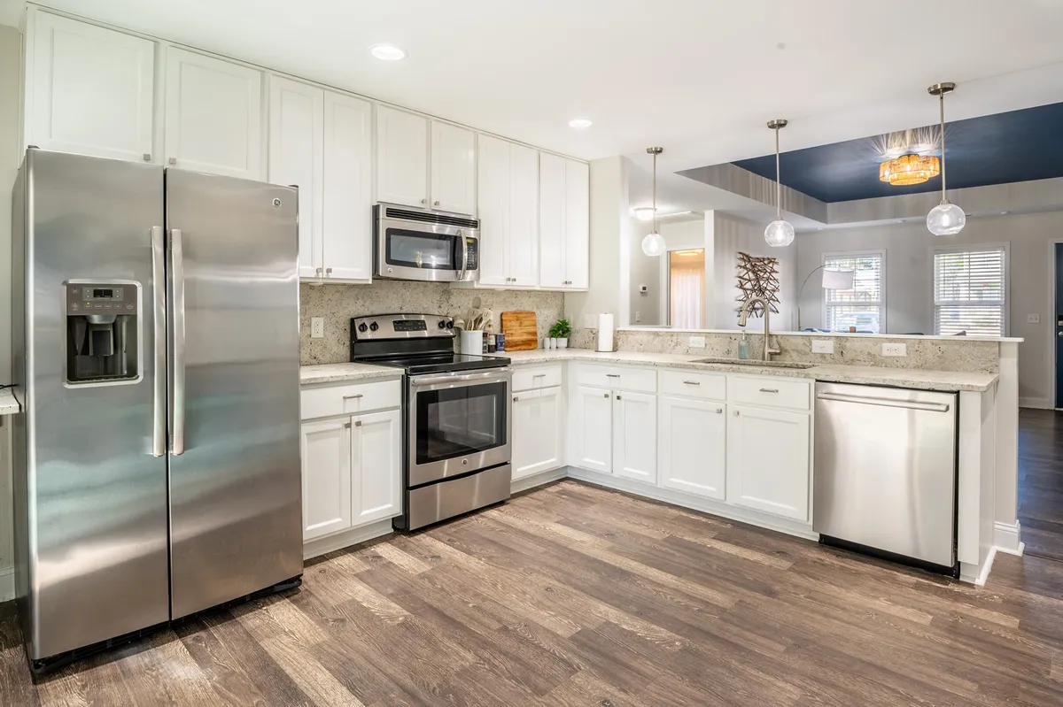 A chef-inspired kitchen with sparkling stainless steel appliances, granite countertops, pendant lighting, and wood flooring. The spacious layout encourages both cooking and social interaction, making it ideal for gatherings.